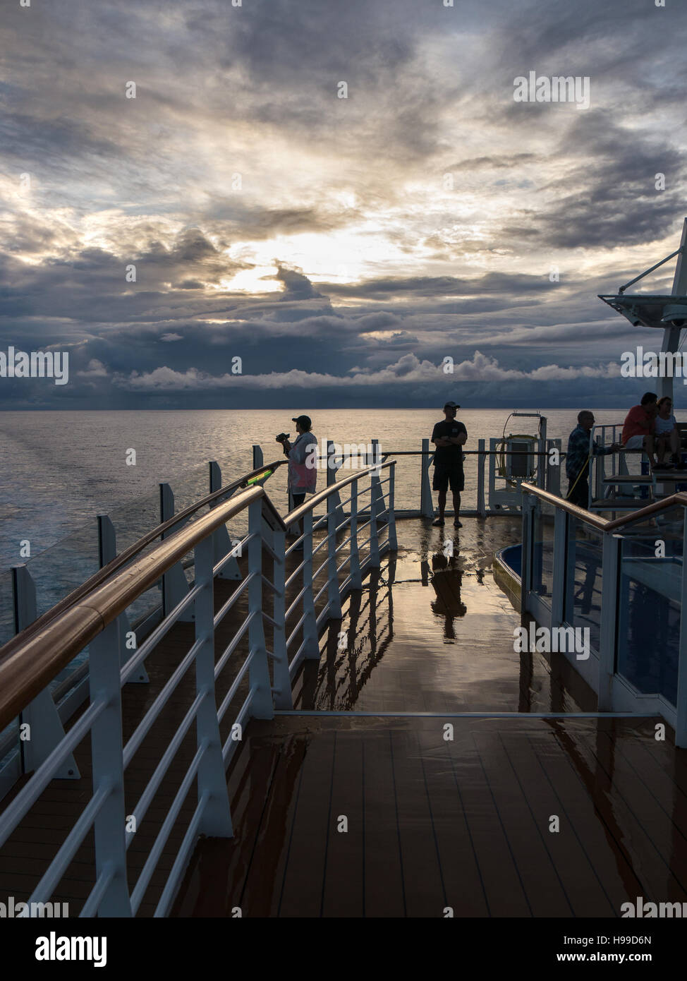 People on the top deck of a cruise ship waiting for sunrise with a ...