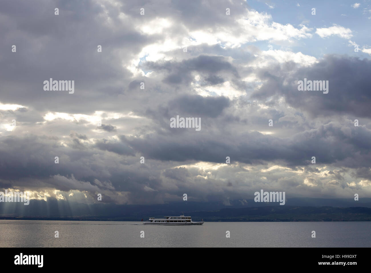 Ferry boat sailing on Lake Geneva under heavy cloud. Stock Photo