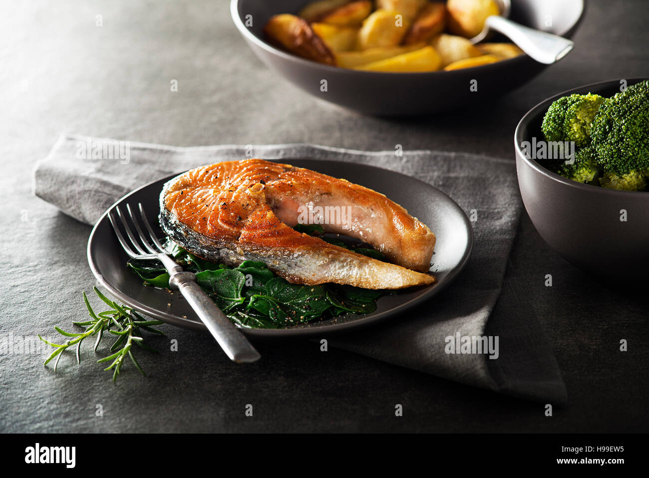Grilled salmon steak with vegetables on dark background Stock Photo - Alamy