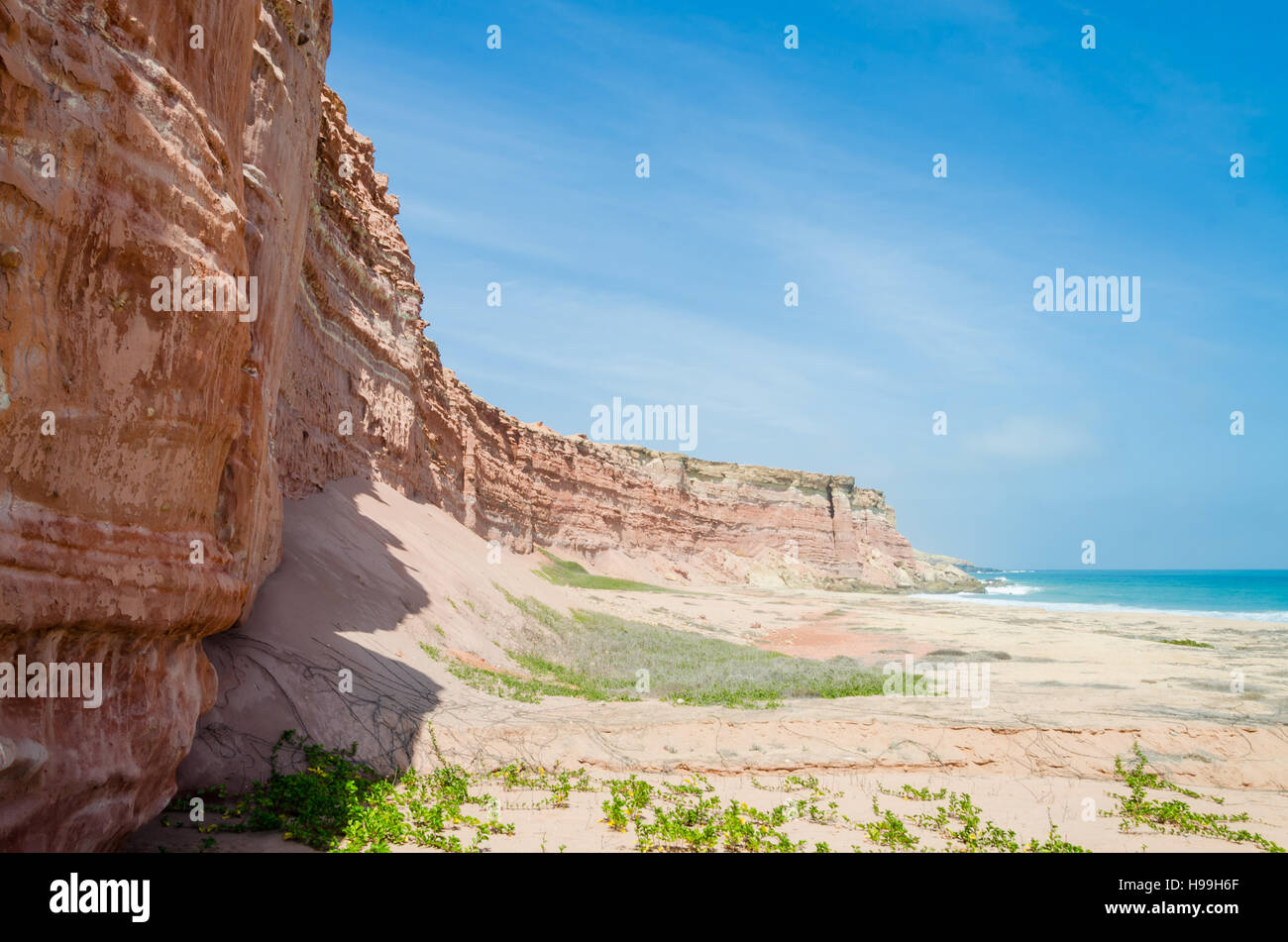Towering red sandstone cliffs at Angola's coast line of the Namib Desert. Stock Photo