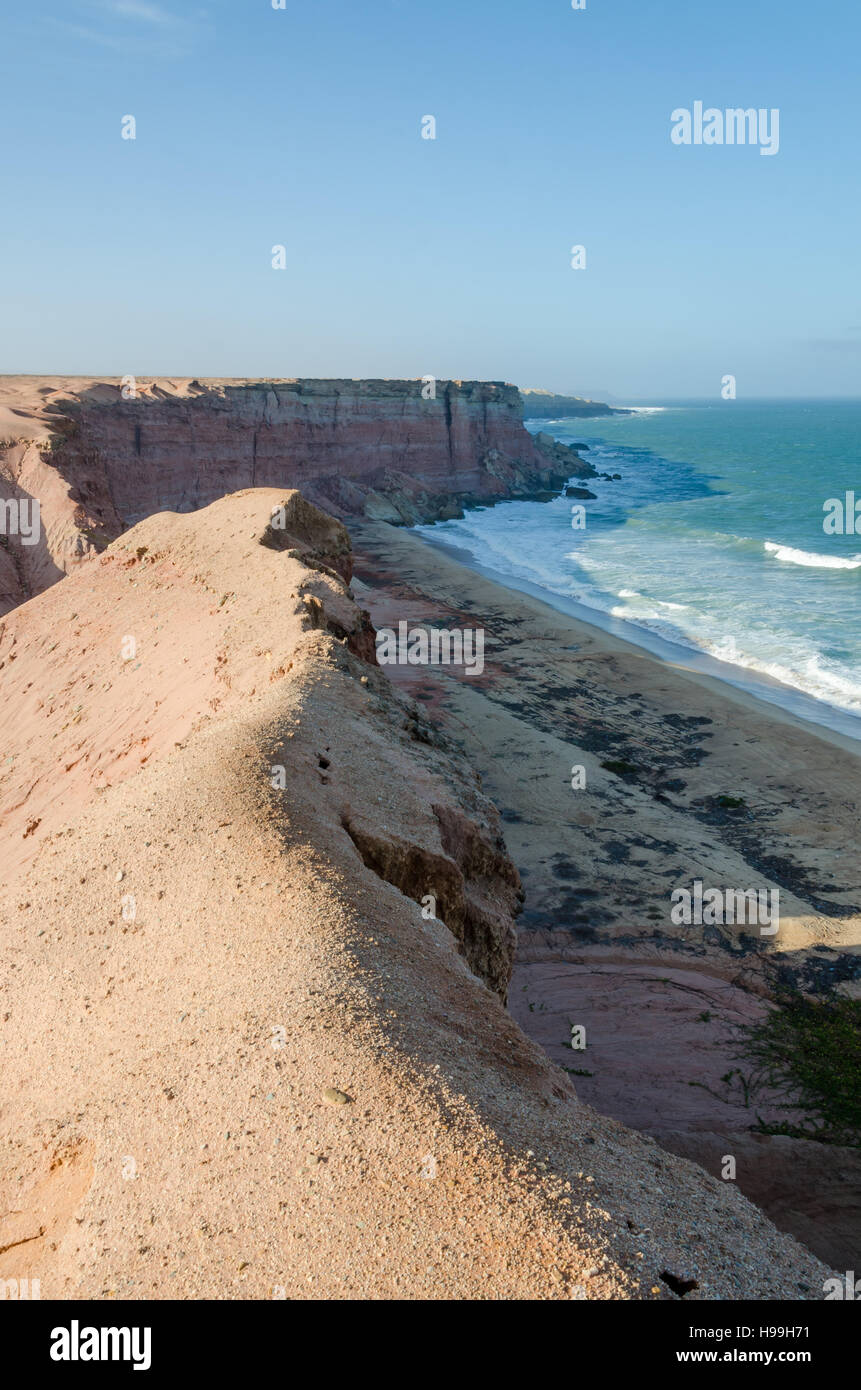 Rough coast line with towering cliffs and wild ocean in Angola's Namib Desert. Stock Photo