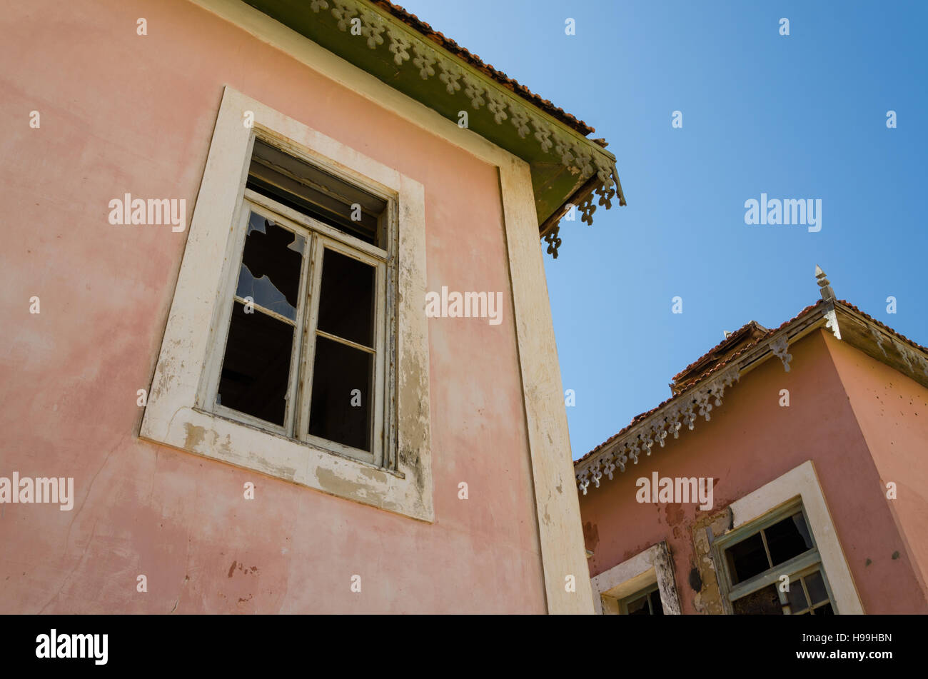 Large pink ruined mansion from Portuguese colonial times in small coastal village of Angola's Namib Desert. Stock Photo