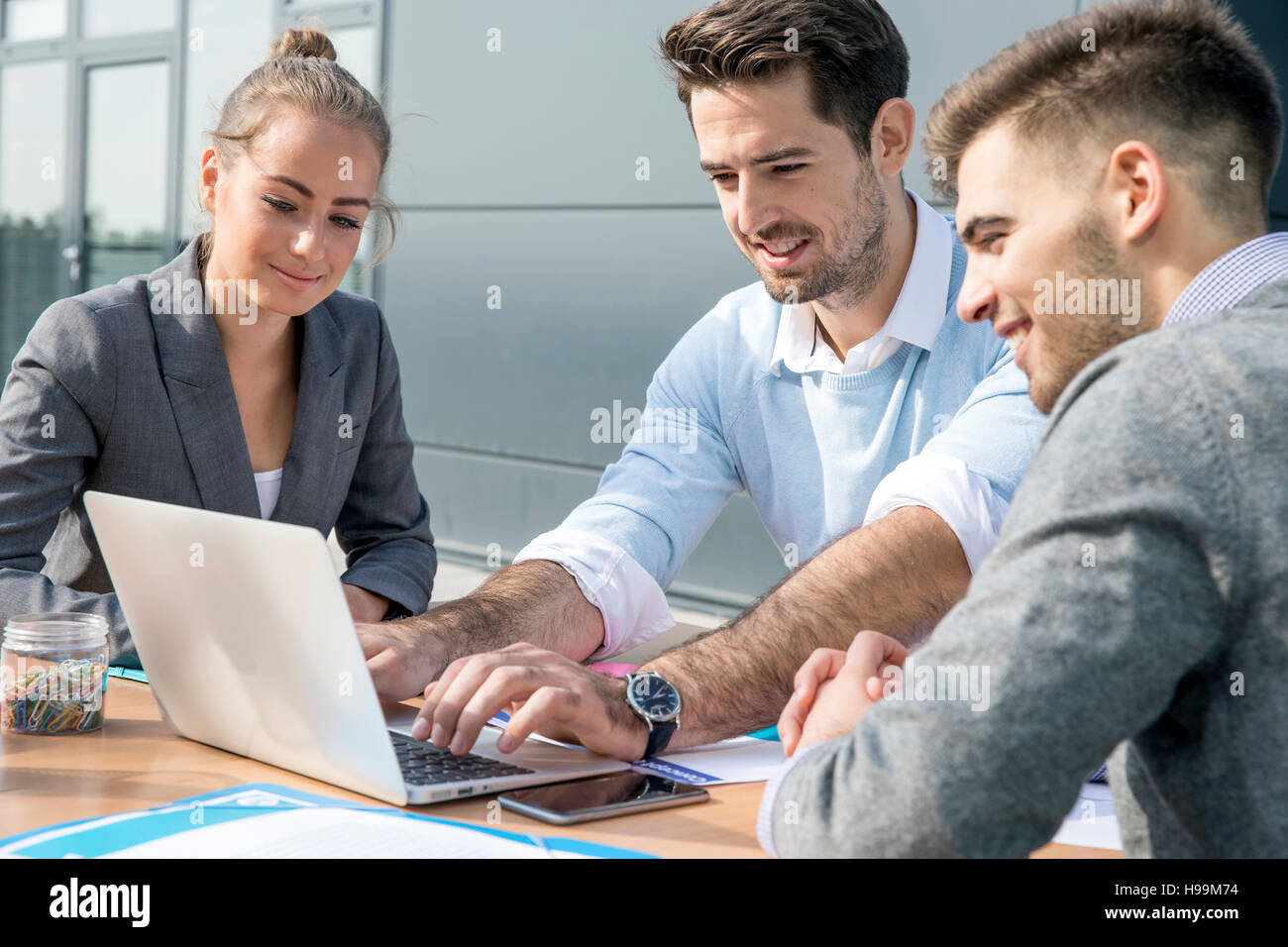 Business people working on laptop together Stock Photo