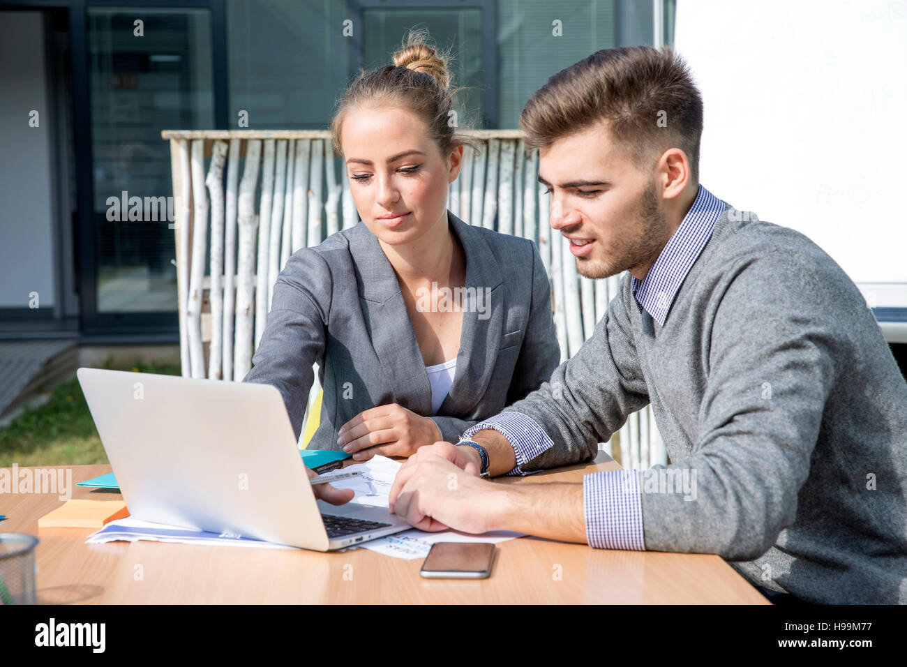Two business people working on laptop together Stock Photo