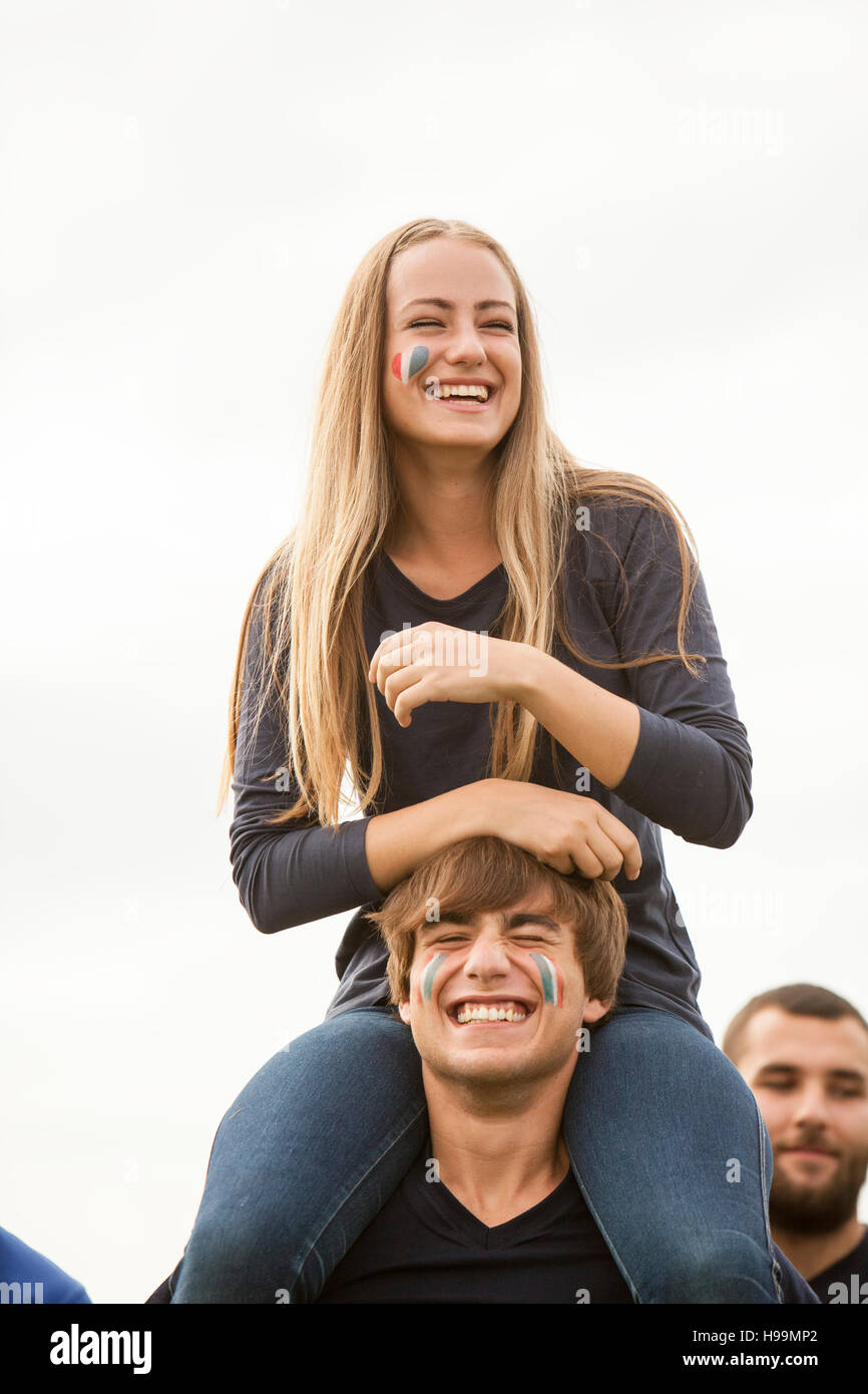Young soccer fan carrying girlfriend on shoulders Stock Photo