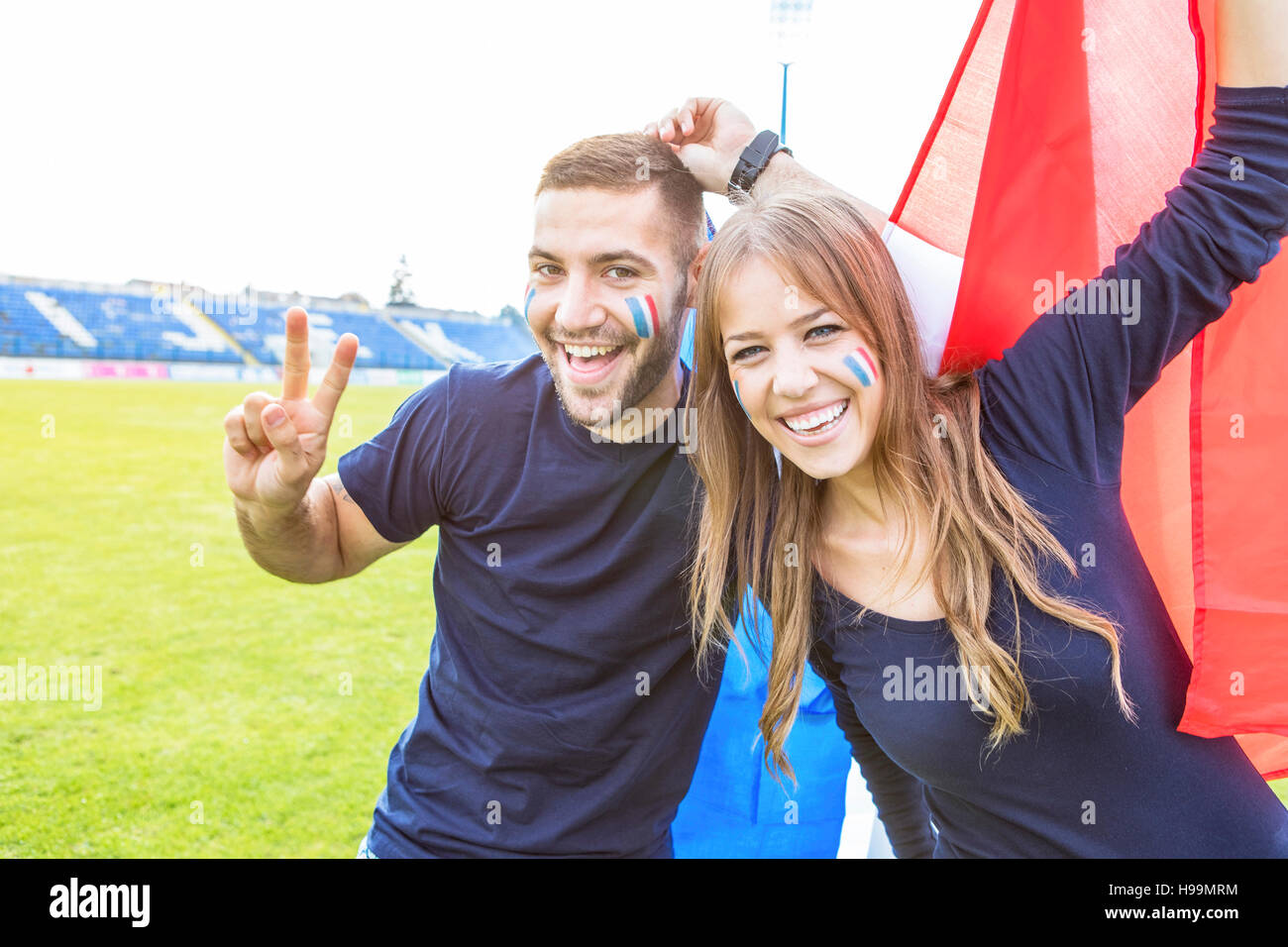 Young couple with face paint and French flag Stock Photo