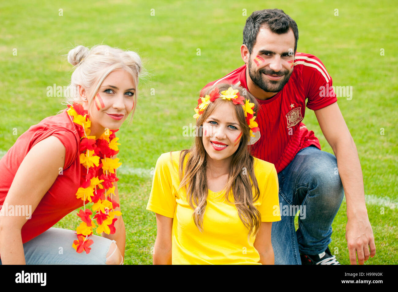 Spanish soccer friends with face paint and floral garland Stock Photo