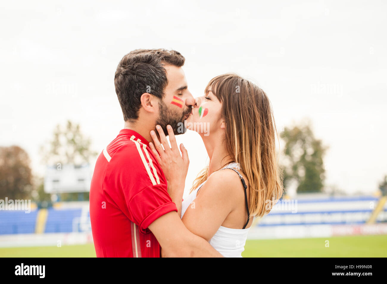 Young couple with face paint kissing Stock Photo