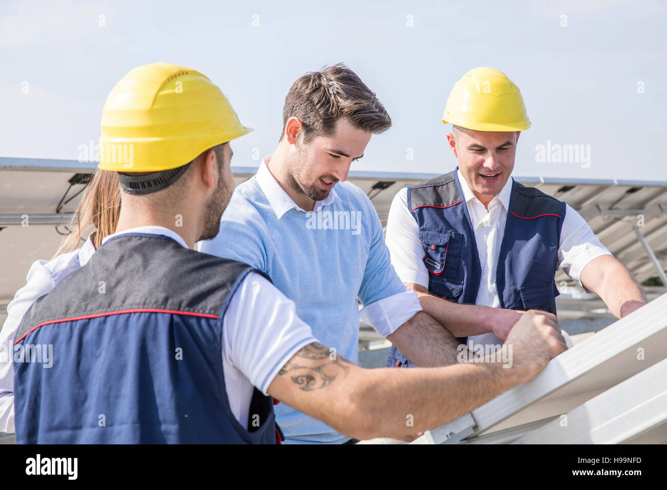 Architects and construction workers inspecting solar power station Stock Photo