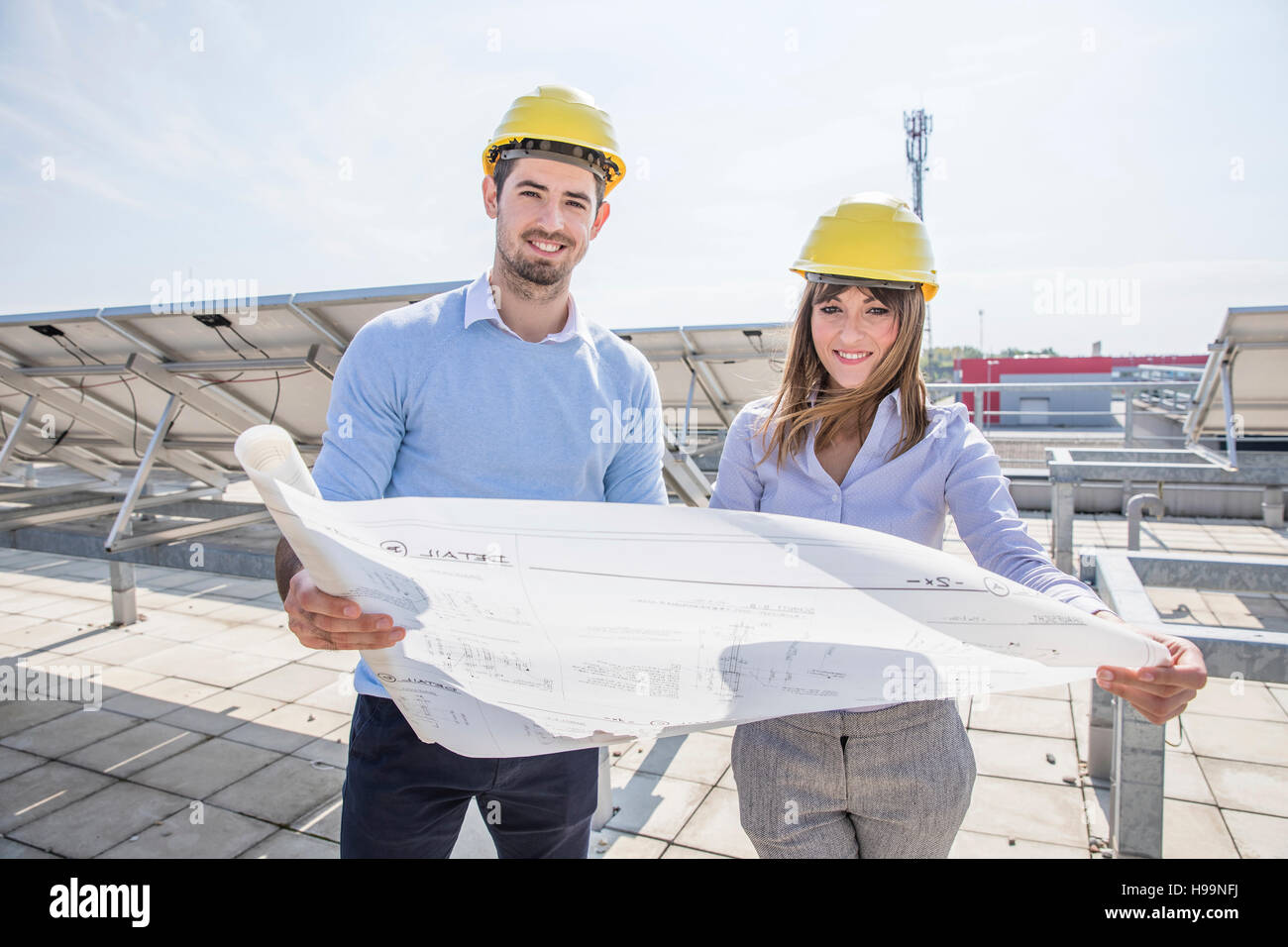 Two architects with blueprint at solar power station Stock Photo