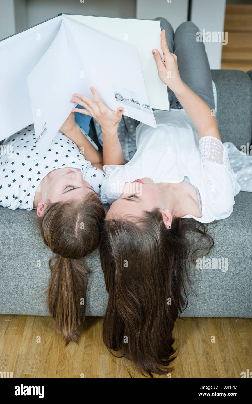 Two teenage girls reading book in bedroom Stock Photo