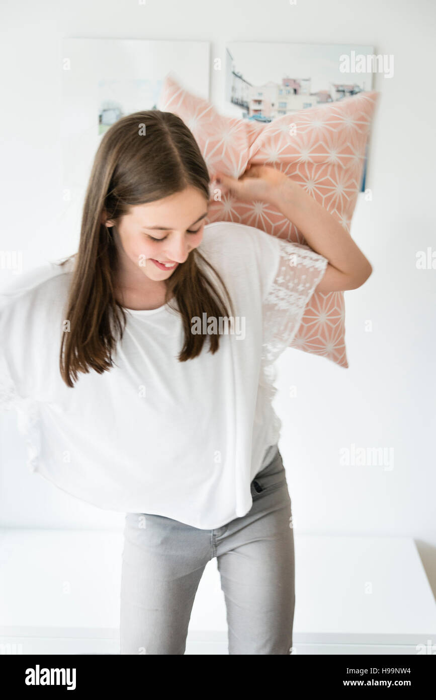 Teenage girl having a pillow fight Stock Photo