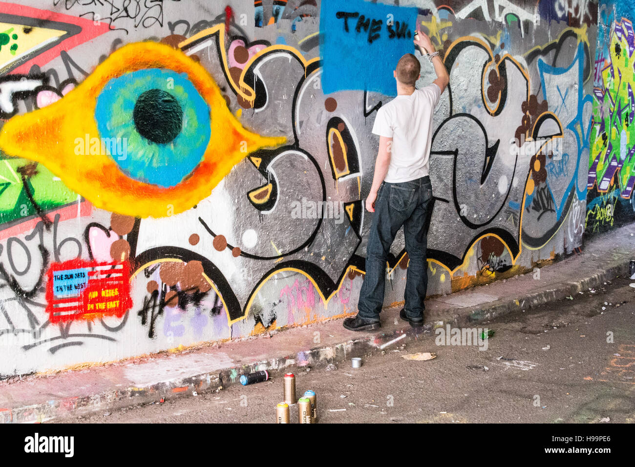 A street artist on Leake Street, also known as Graffiti Tunnel, underneath Waterloo Train Station, Lambeth, London, SE1, UK. Stock Photo