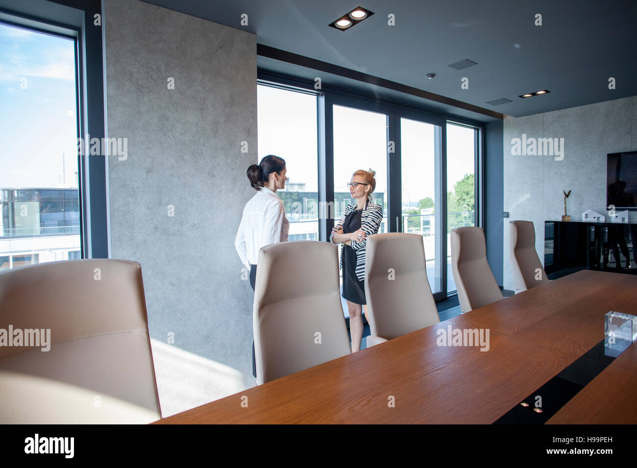 Two businesswomen talking in board room Stock Photo