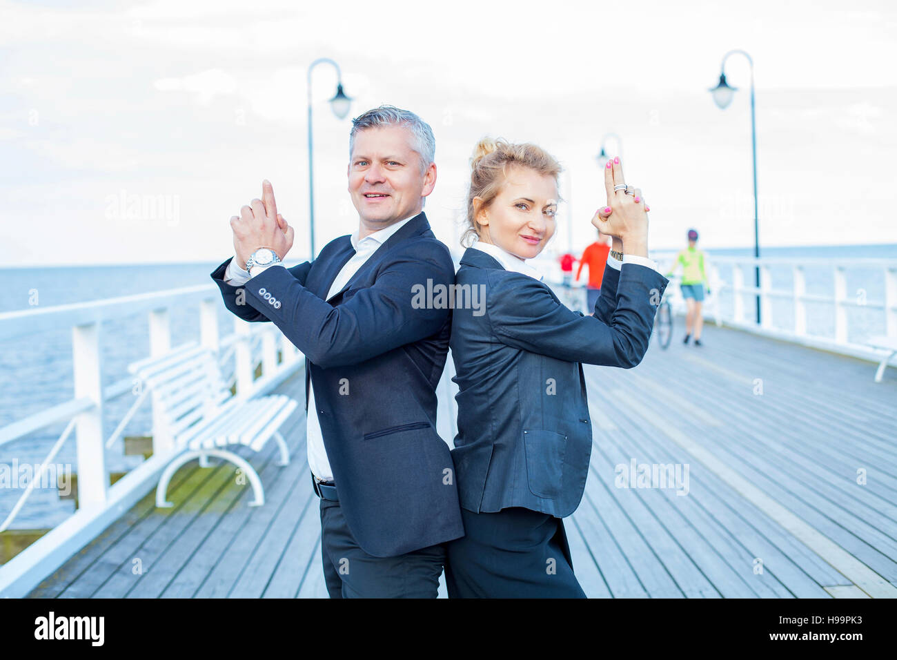 Two business people making finger gun gesture Stock Photo