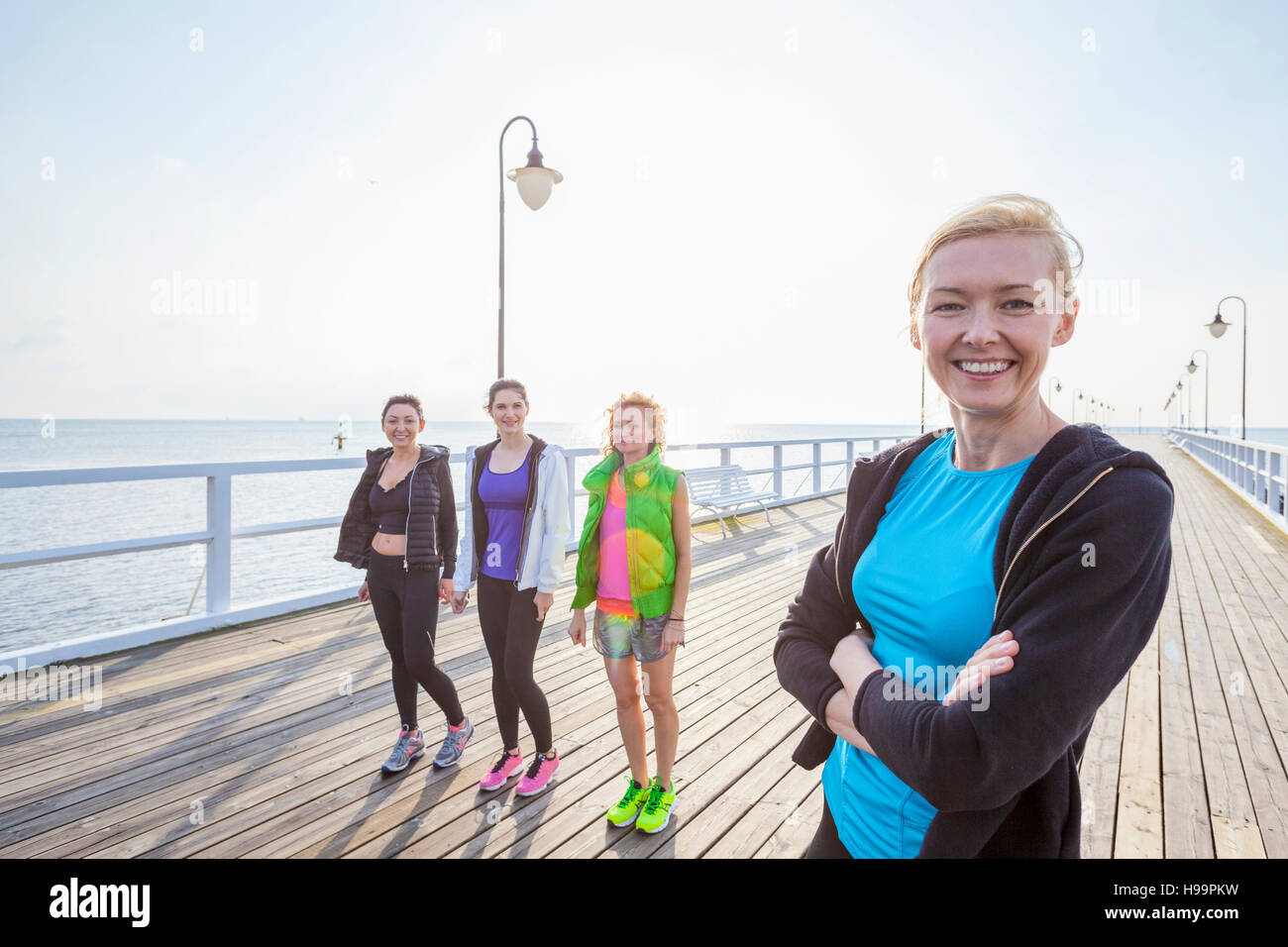 Group of women in sports clothing standing on jetty Stock Photo