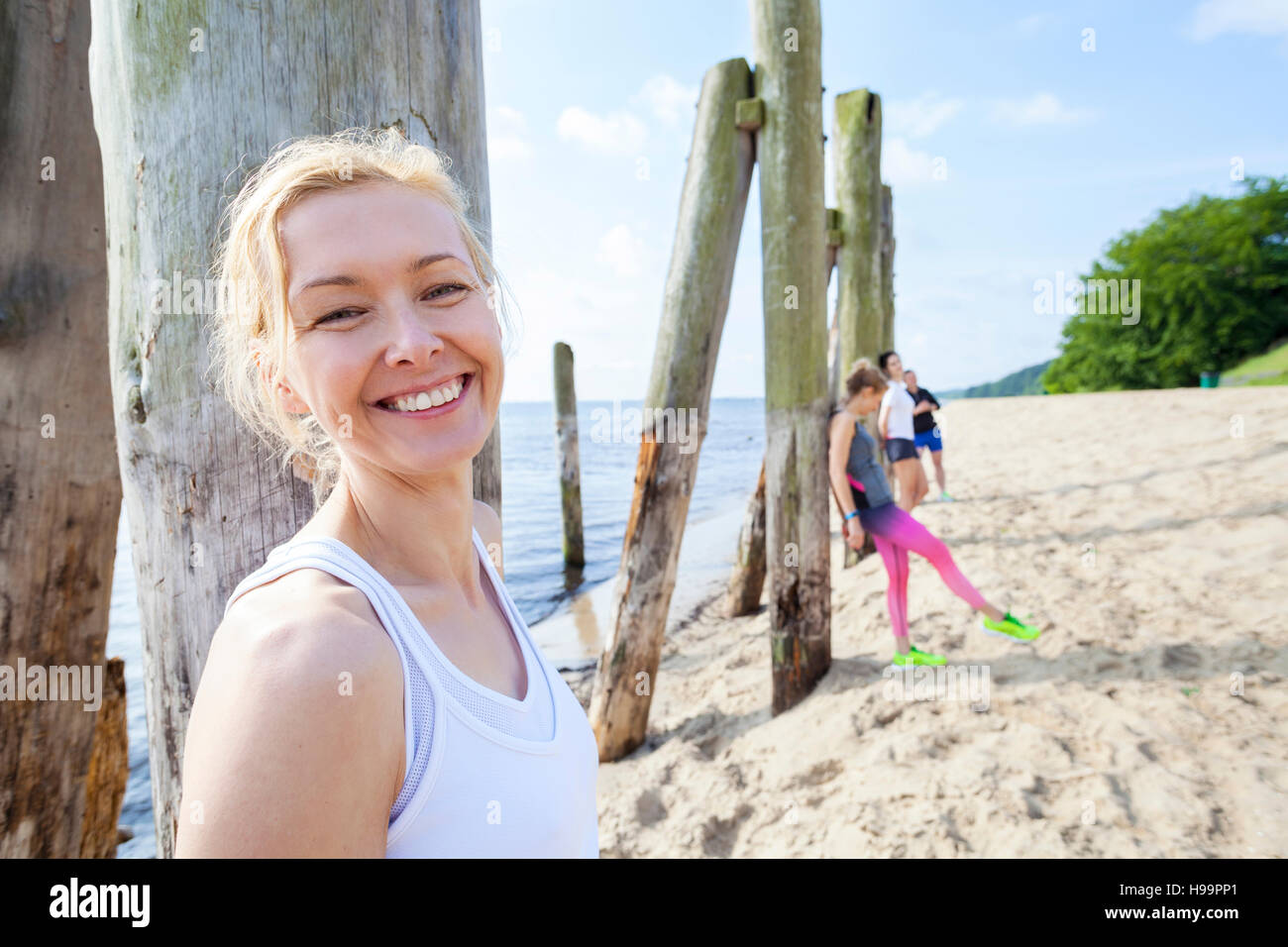 Young woman and friends on beach taking a break Stock Photo