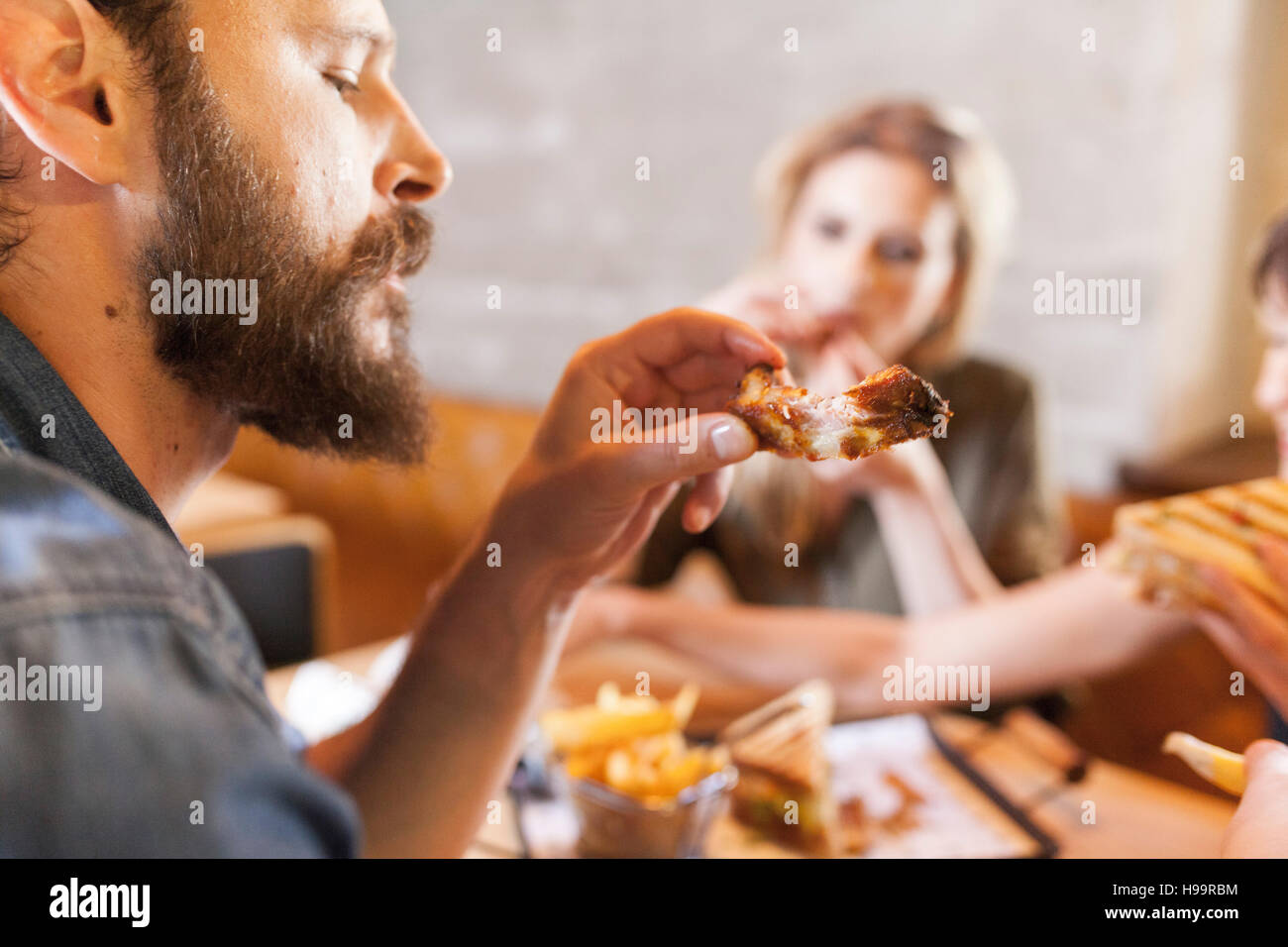 Friends in coffee shop eating snacks Stock Photo Alamy