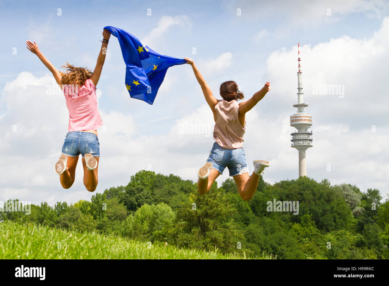 Two women jumping while holding European flag Stock Photo