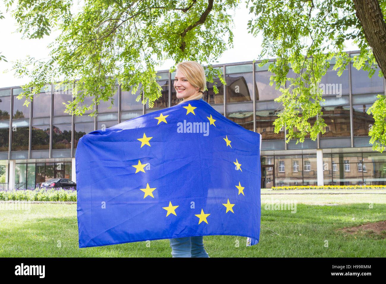 Young woman holding European Union flag outdoors Stock Photo - Alamy