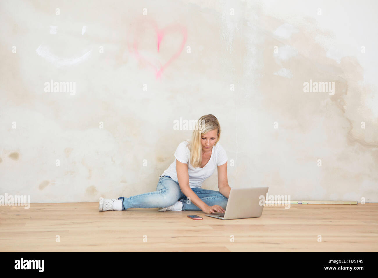 Woman using laptop during renovation in apartment Stock Photo