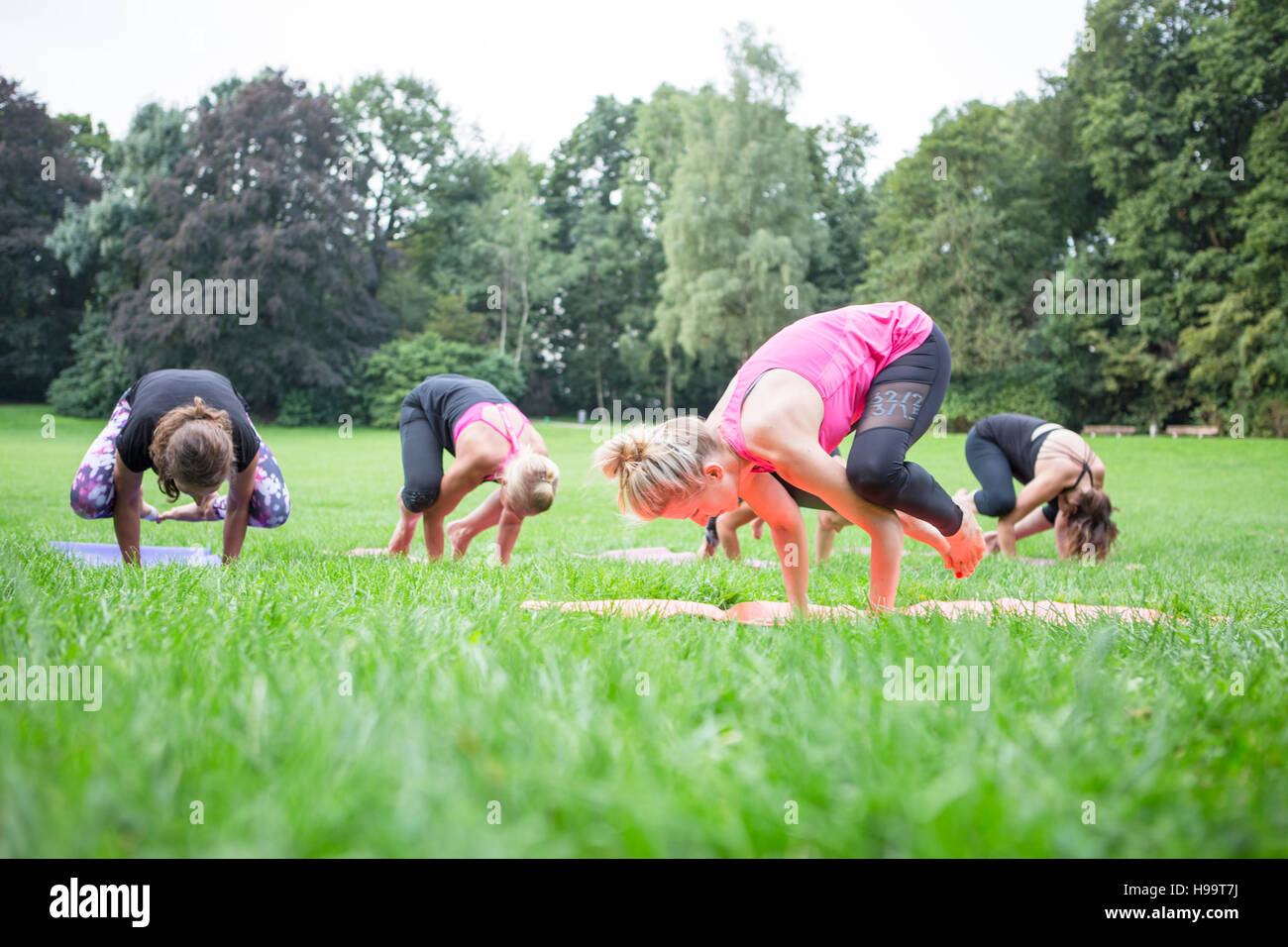 Young women practicing yoga in park Stock Photo