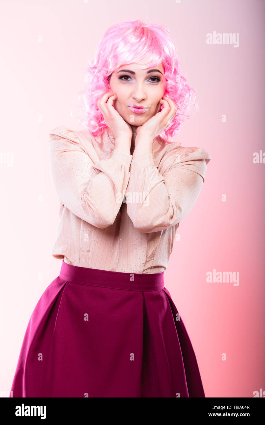 Portrait woman with pink wig creative visage makeup posing on gray background Stock Photo