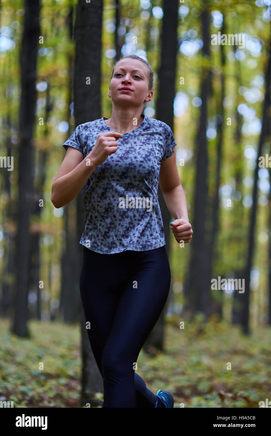 Young woman trail running through forest in the autumn Stock Photo - Alamy