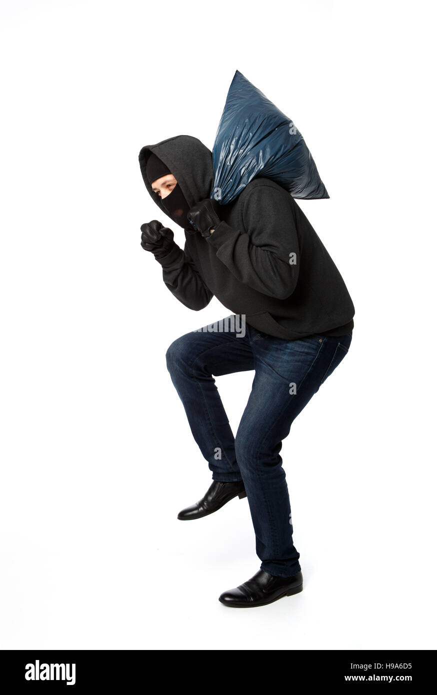 Burglar slinking with large bag Stock Photo