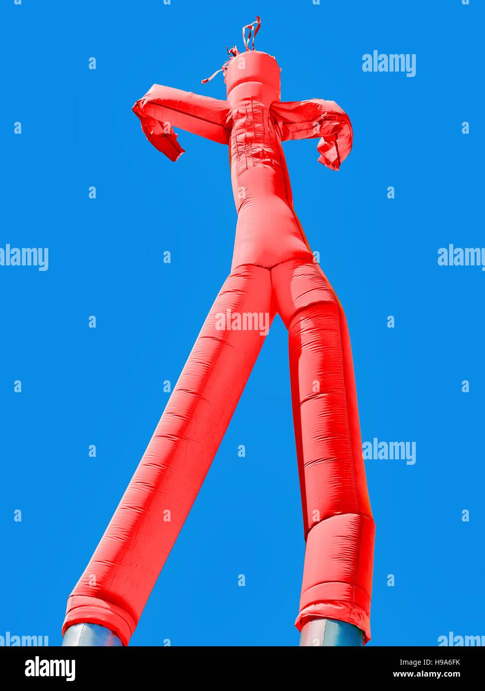 Red inflatable man on blue sky background Stock Photo