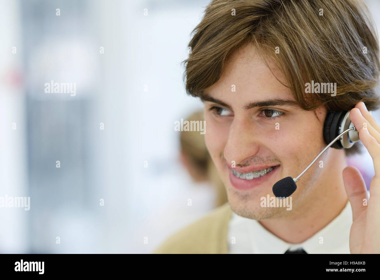 Smiling young call center executive at startup office Stock Photo
