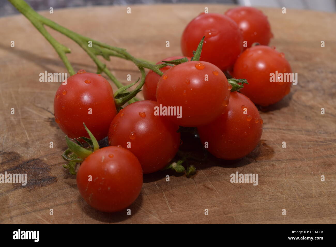 Tomatoes on a wooden chopping board Stock Photo - Alamy