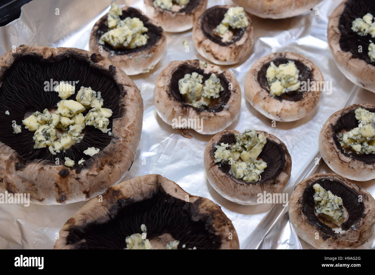 Mushrooms laid on tin foil in a baking tray ready for preparation Stock