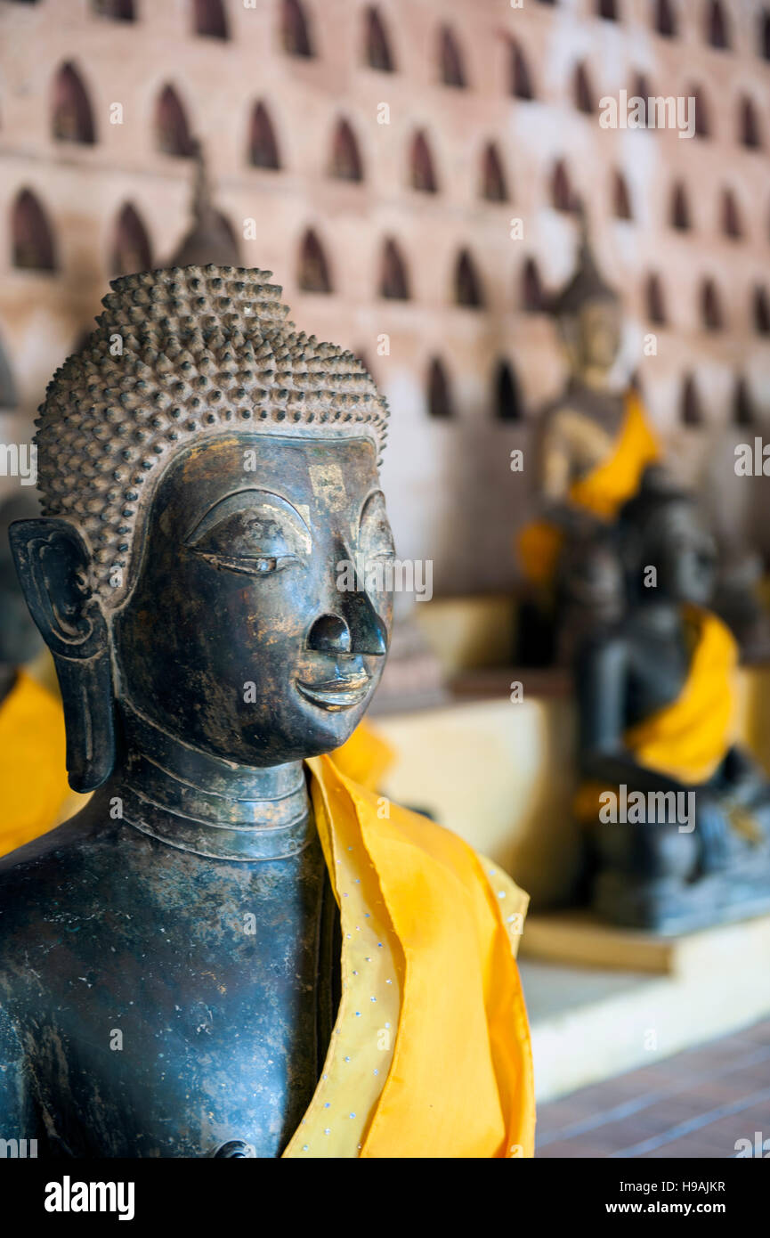 A few of 2000 silver and ceramic Buddha statues crowd Wat Sisatek's cloister walls, a Buddhist temple in Vientiane, Laos. Stock Photo