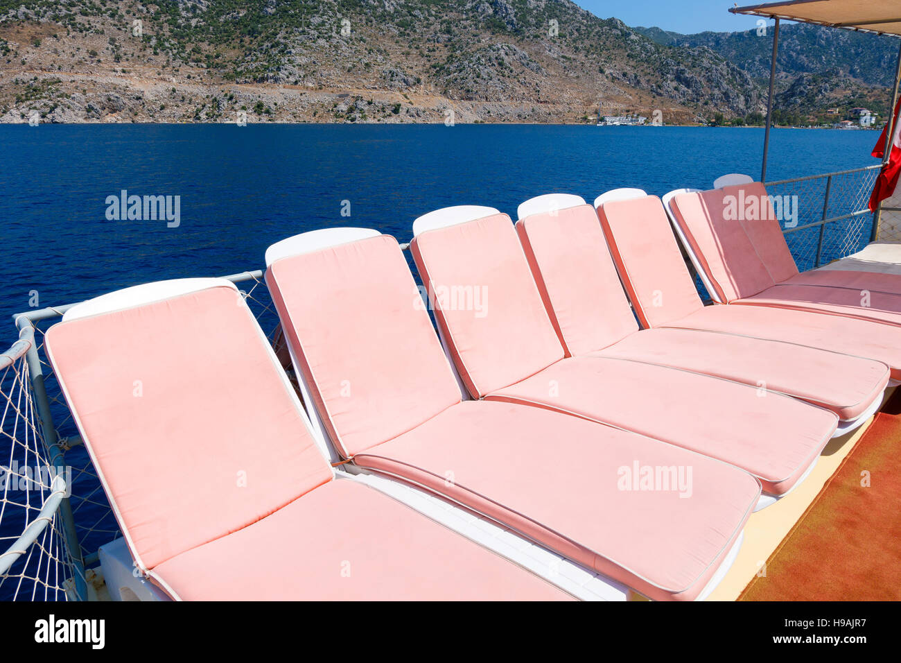 Pink sun beds on a boat in the sea, Turkey Stock Photo