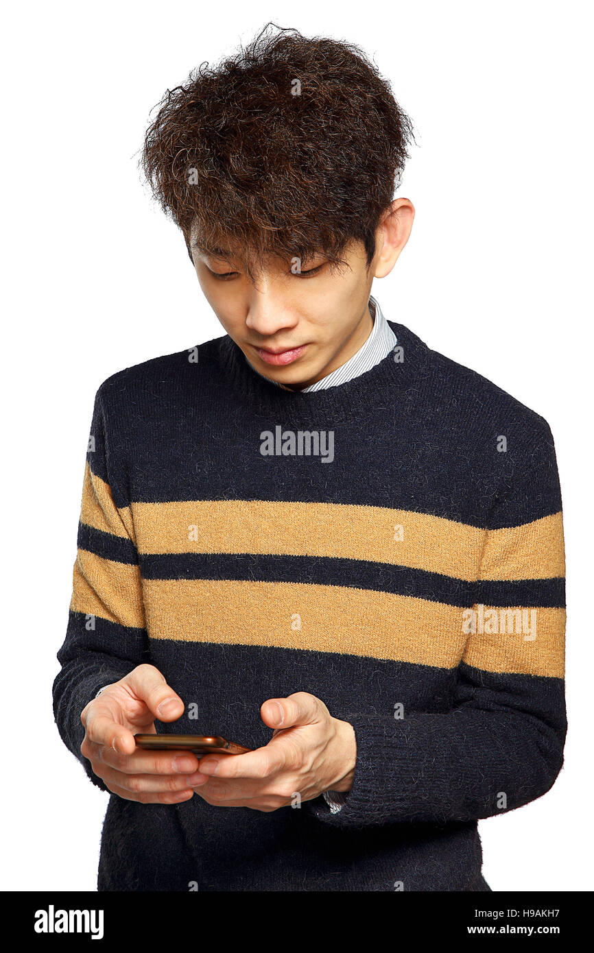 young asia man texting on mobilephone, thinking and looking away. Stock Photo