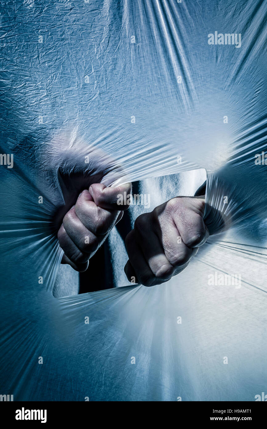 Hands ripping open a polythene screen. Stock Photo