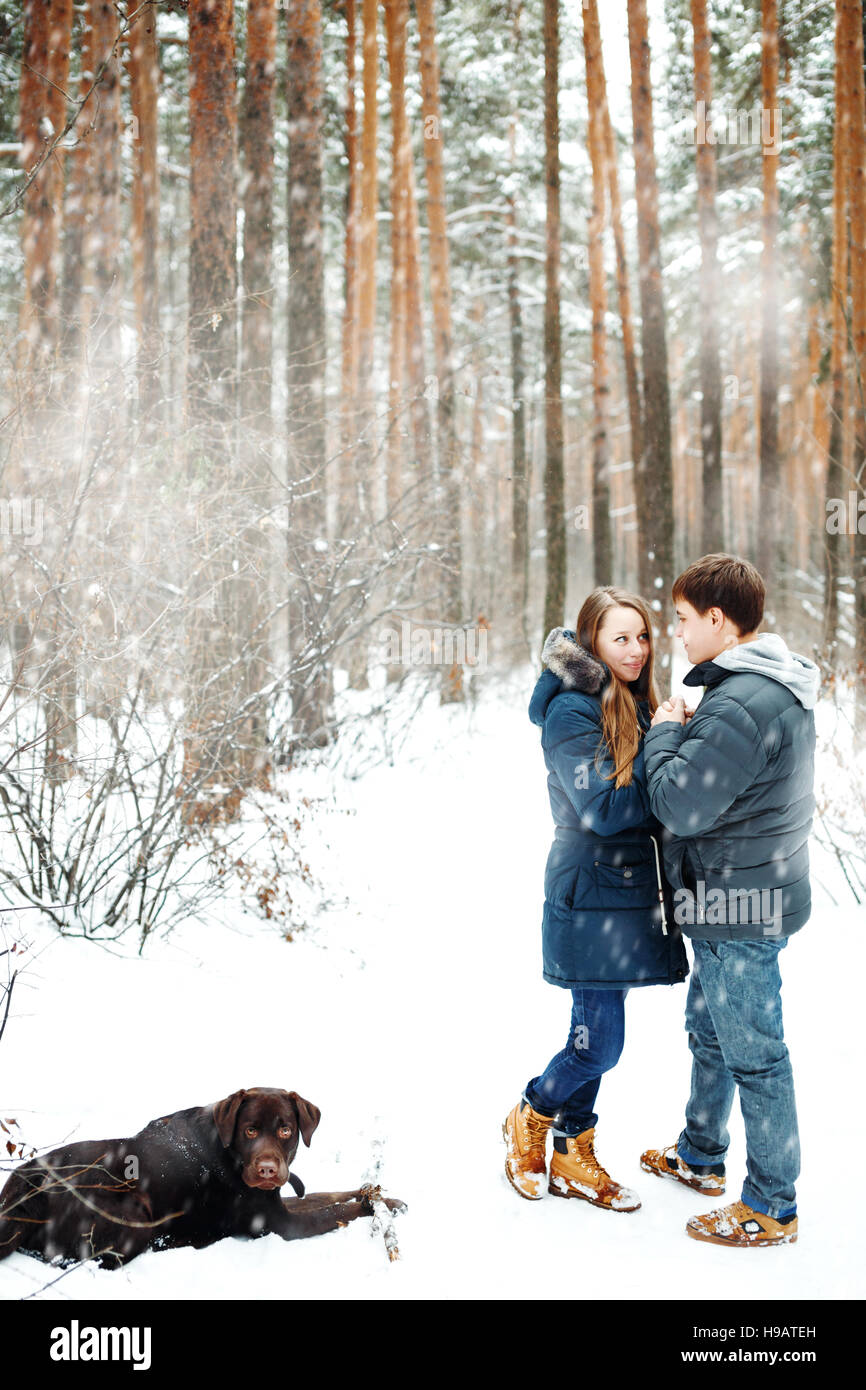 Couple in love having fun with labrador dog, winter forest at the ...