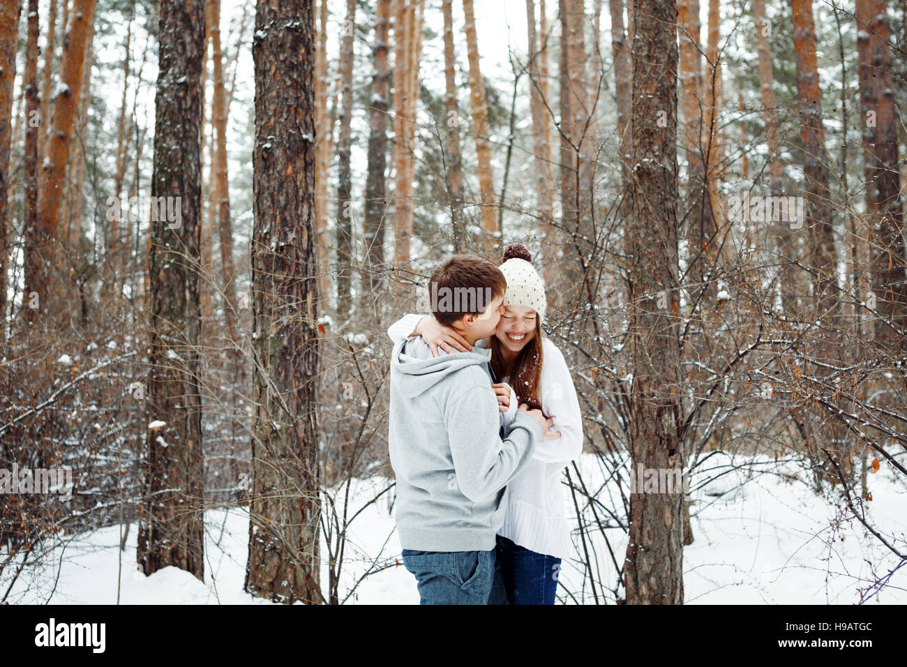 Couple in love having fun, winter forest at the background Stock Photo ...