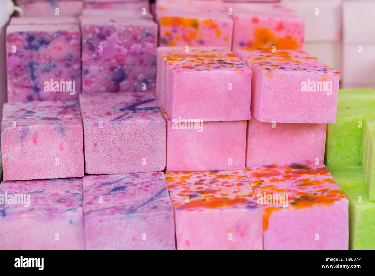 Colorful pink, purple and lime green marbled blocks of handmade soap on stall at craft market Stock Photo