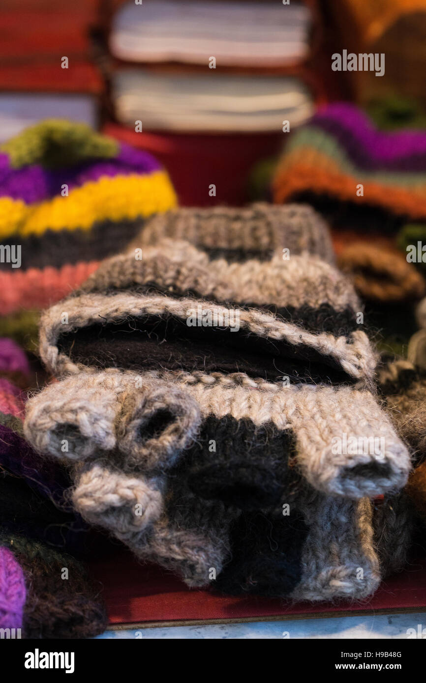 Piles of handmade wool fingerless stripe glove mittens displayed on a stall at a craft artisanal market Stock Photo