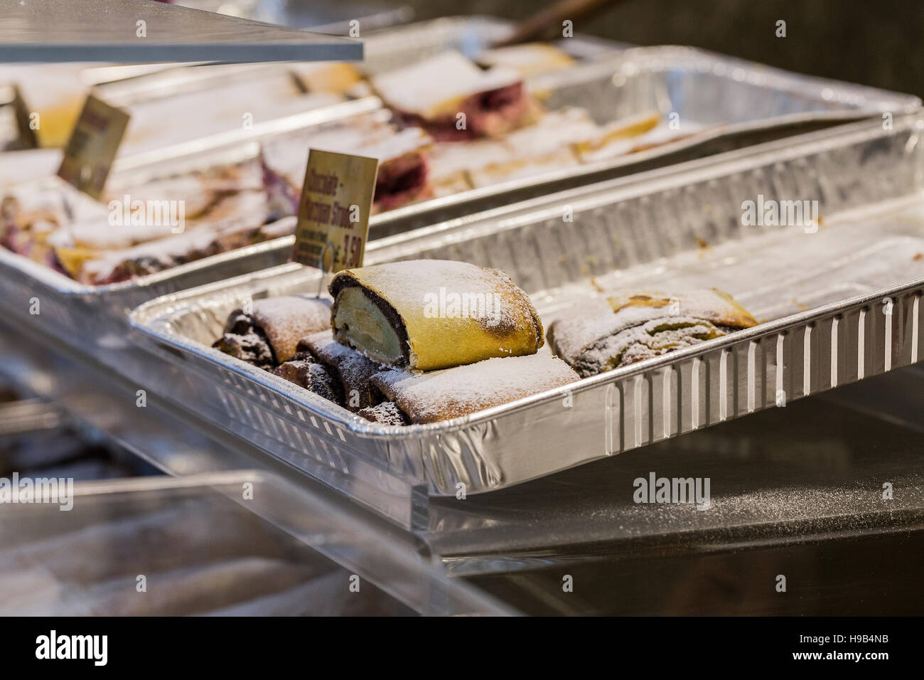 Trays of delicacies on servery including chocolate dusted strudel with price card Stock Photo