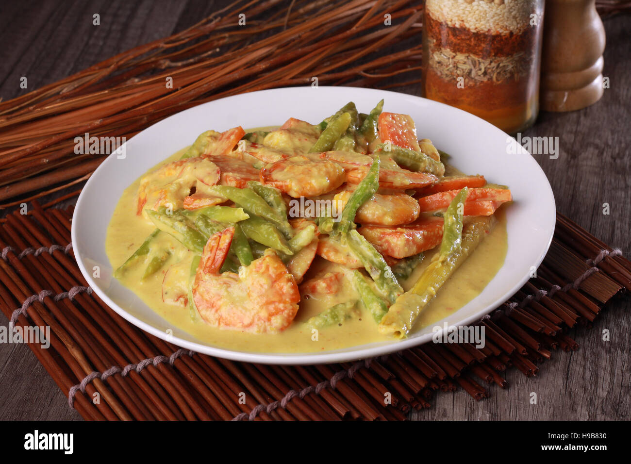 Malaysian prawn in spicy coconut milk gravy on top wooden background Stock Photo