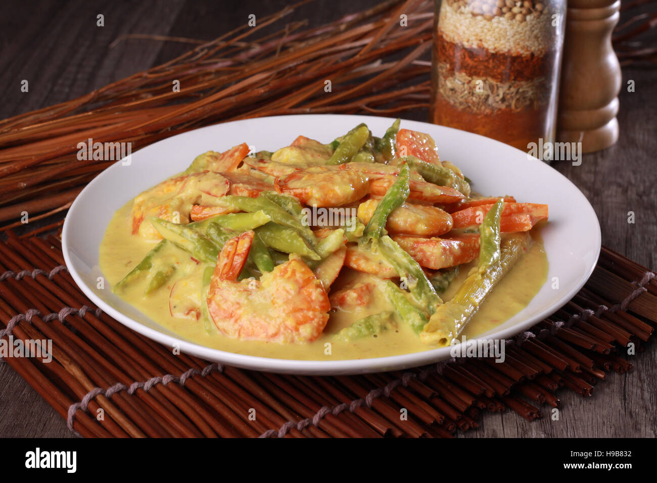 Malaysian prawn in spicy coconut milk gravy on top wooden background
