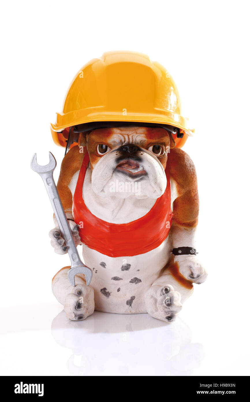 Bulldog figurine wearing a yellow construction helmet and holding a spanner Stock Photo