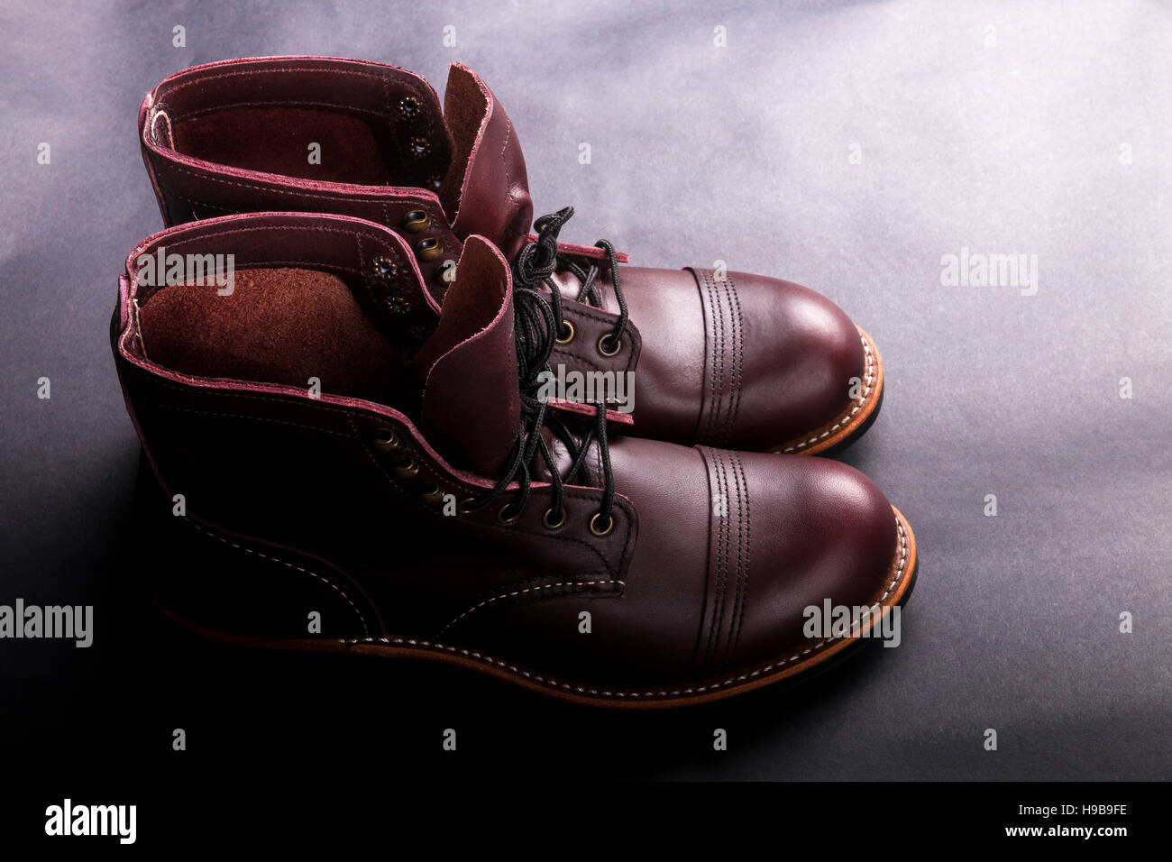 High boots. Fashionable mens leather brown shoes on light black