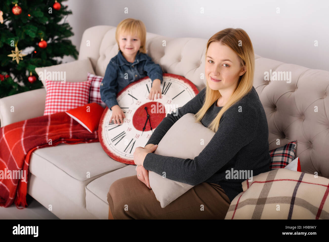 Mother and son sitting near the Christmas tree Stock Photo