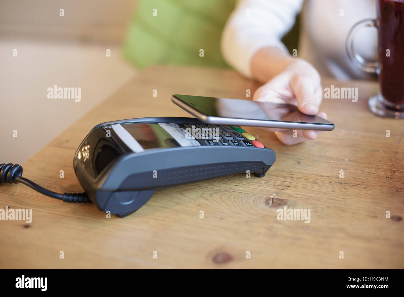 Woman uses smart phone to pay Stock Photo - Alamy