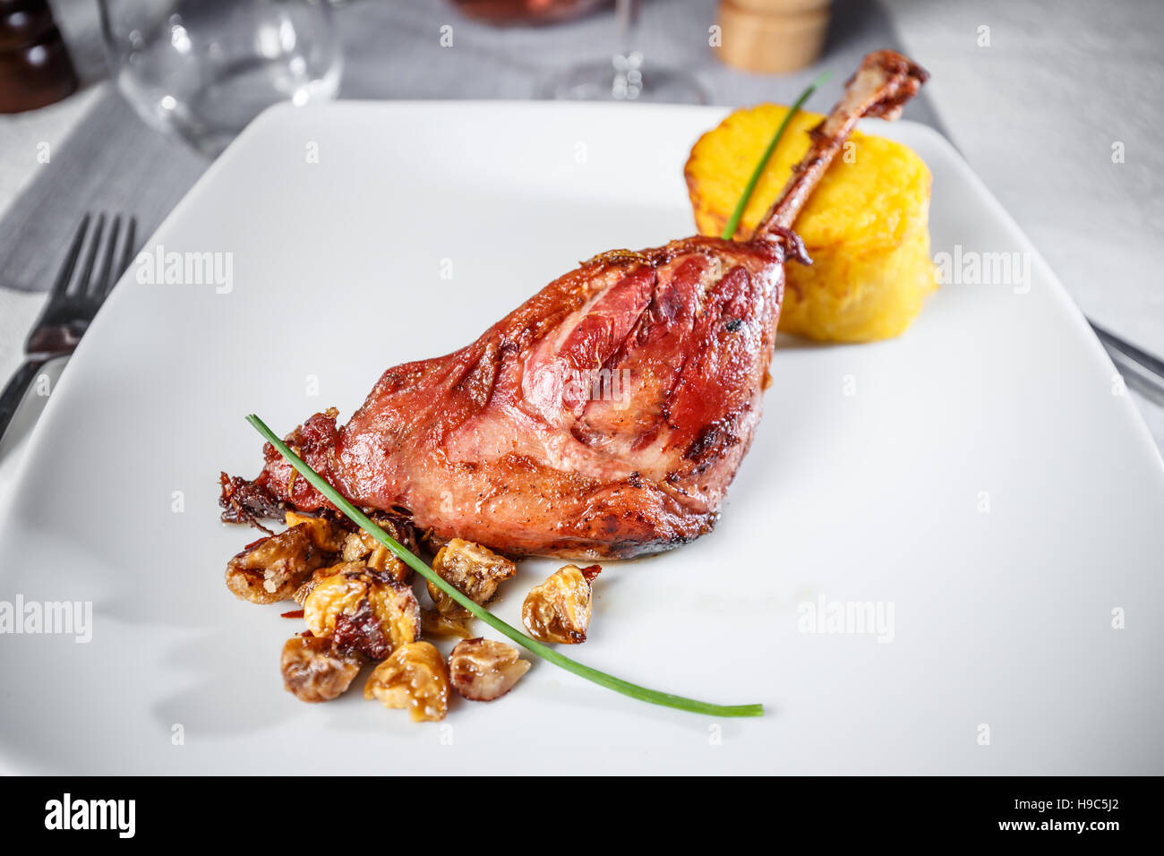 Roasted goose drumstick served with mashed potatoes and chestnuts Stock Photo