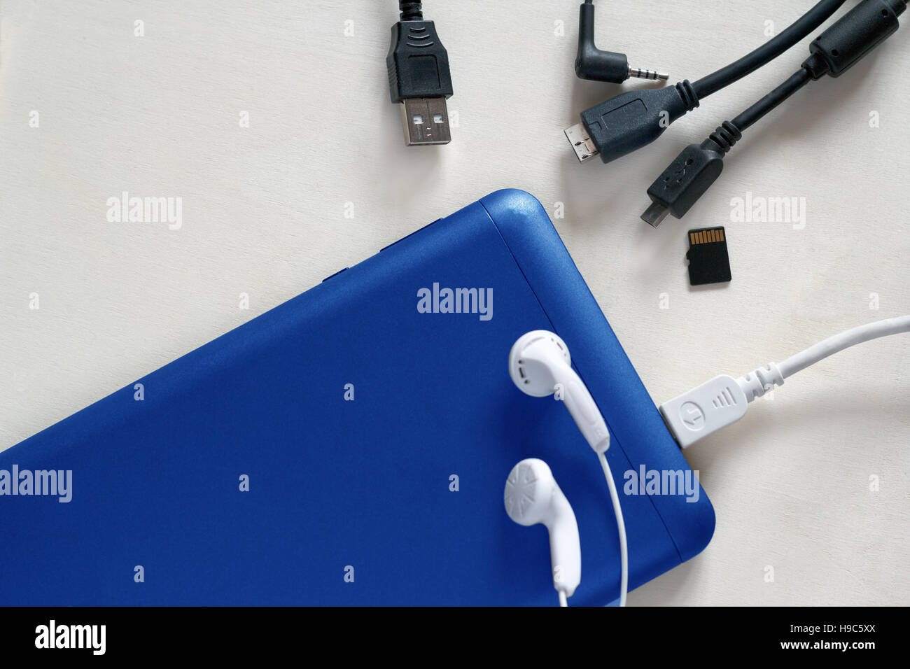 Phone accessories, usb cables, headphones on a white wood background